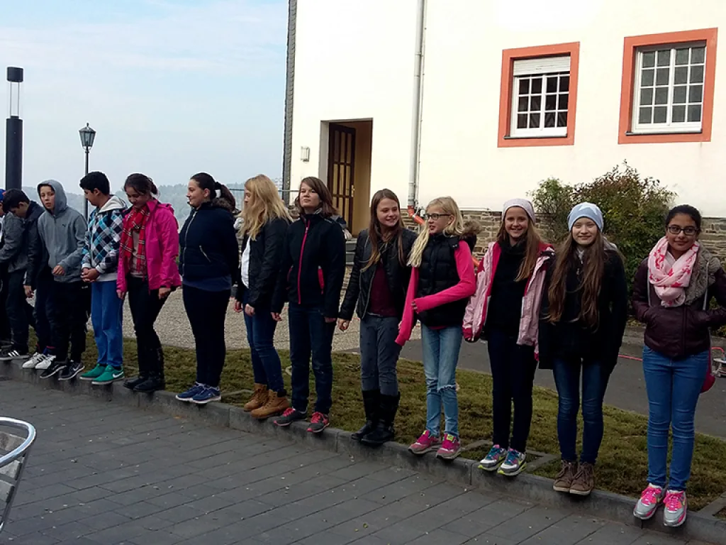 Gruppe steht in einer langen Reihe auf der Wiese.